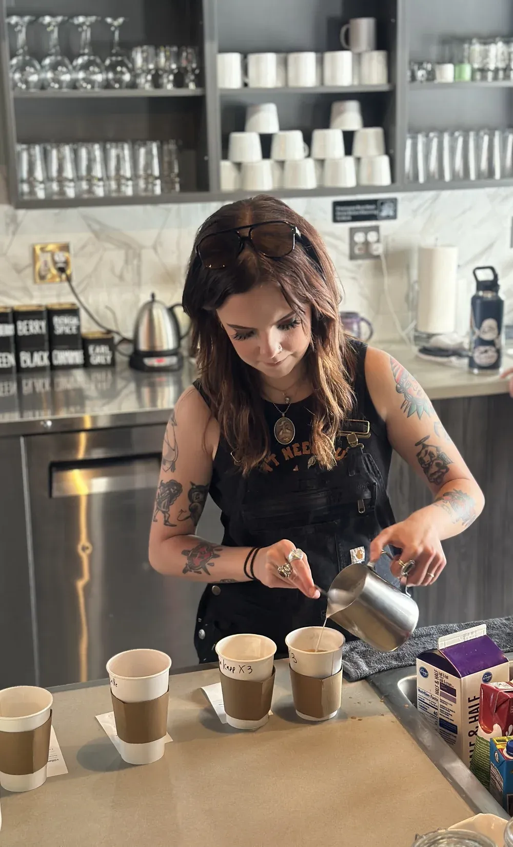 A barista pouring steamed milk into lattes at Mint and Serif in Lakewood